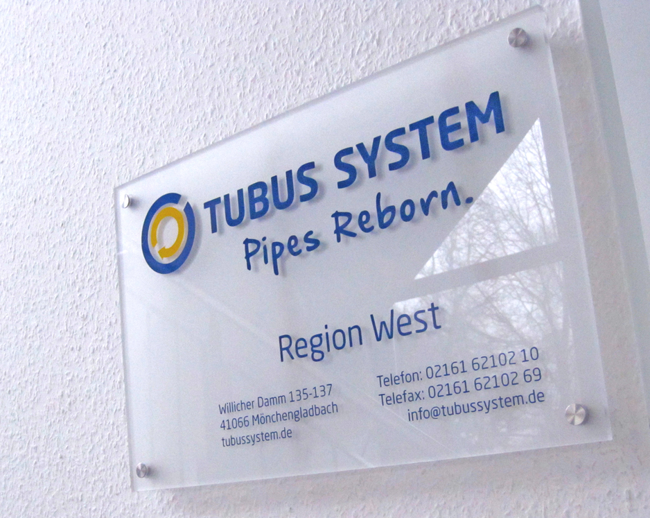 Ein zweifarbiges Acrylschild mit Beschriftung inklusive Wandmontage für das Rohrsanierunternehmen (Rohr in Rohr System) Tubus System GmbH in Mönchengladbach-Neuwerk.