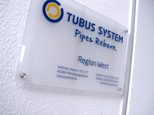 Ein zweifarbiges Acrylschild mit Beschriftung inklusive Wandmontage für das Rohrsanierunternehmen (Rohr in Rohr System) Tubus System GmbH in Mönchengladbach-Neuwerk.