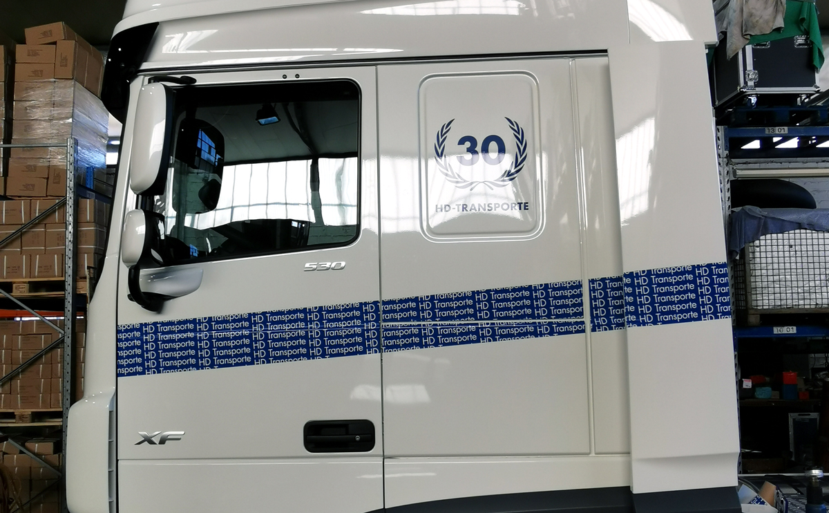 LKW-Beschriftung (Führerhaus) eines  DAF XF 530 mit Folienschrift und einer im Digitaldruck bedruckten Vollverklebungsfolie für H. D. Transporte Internationale Spedition GmbH in Grevenbroich-Wevelinghoven.