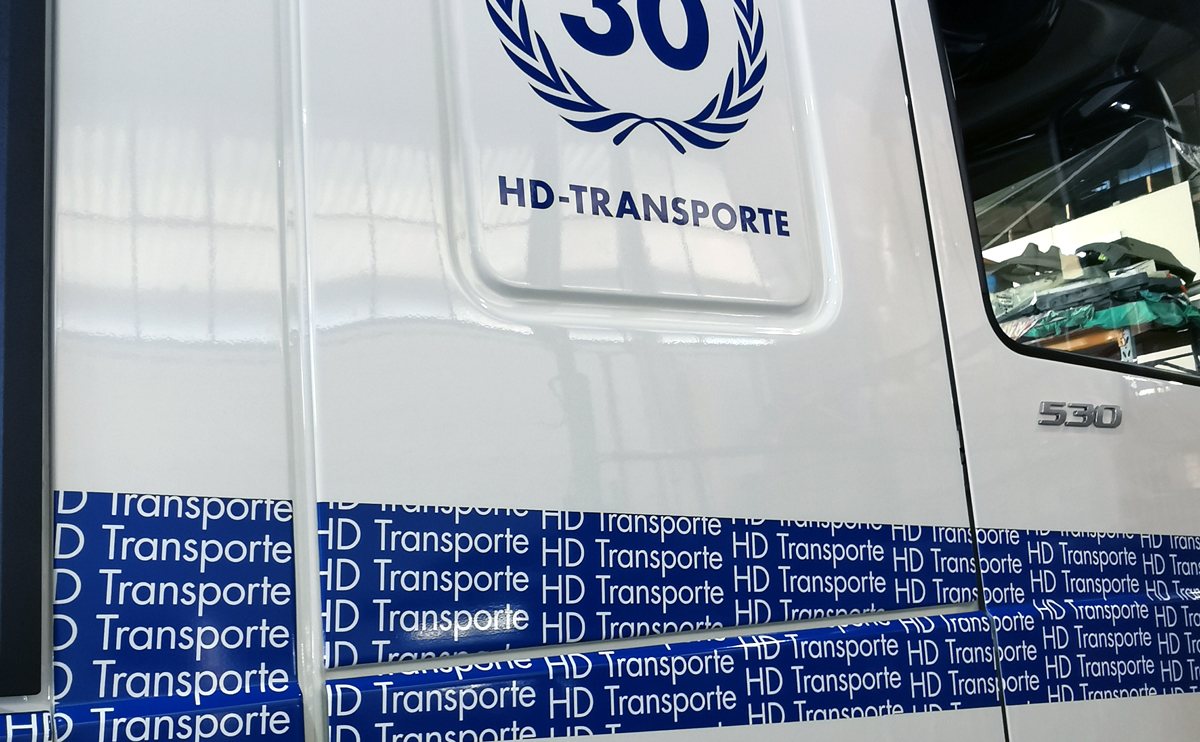 LKW-Beschriftung (Führerhaus) eines  DAF XF 530 mit Folienschrift und einer im Digitaldruck bedruckten Vollverklebungsfolie für H. D. Transporte Internationale Spedition GmbH in Grevenbroich-Wevelinghoven.