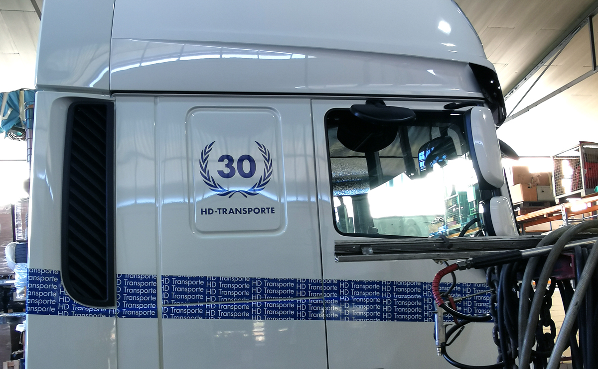 LKW-Beschriftung (Führerhaus) eines  DAF XF 530 mit Folienschrift und einer im Digitaldruck bedruckten Vollverklebungsfolie für H. D. Transporte Internationale Spedition GmbH in Grevenbroich-Wevelinghoven.