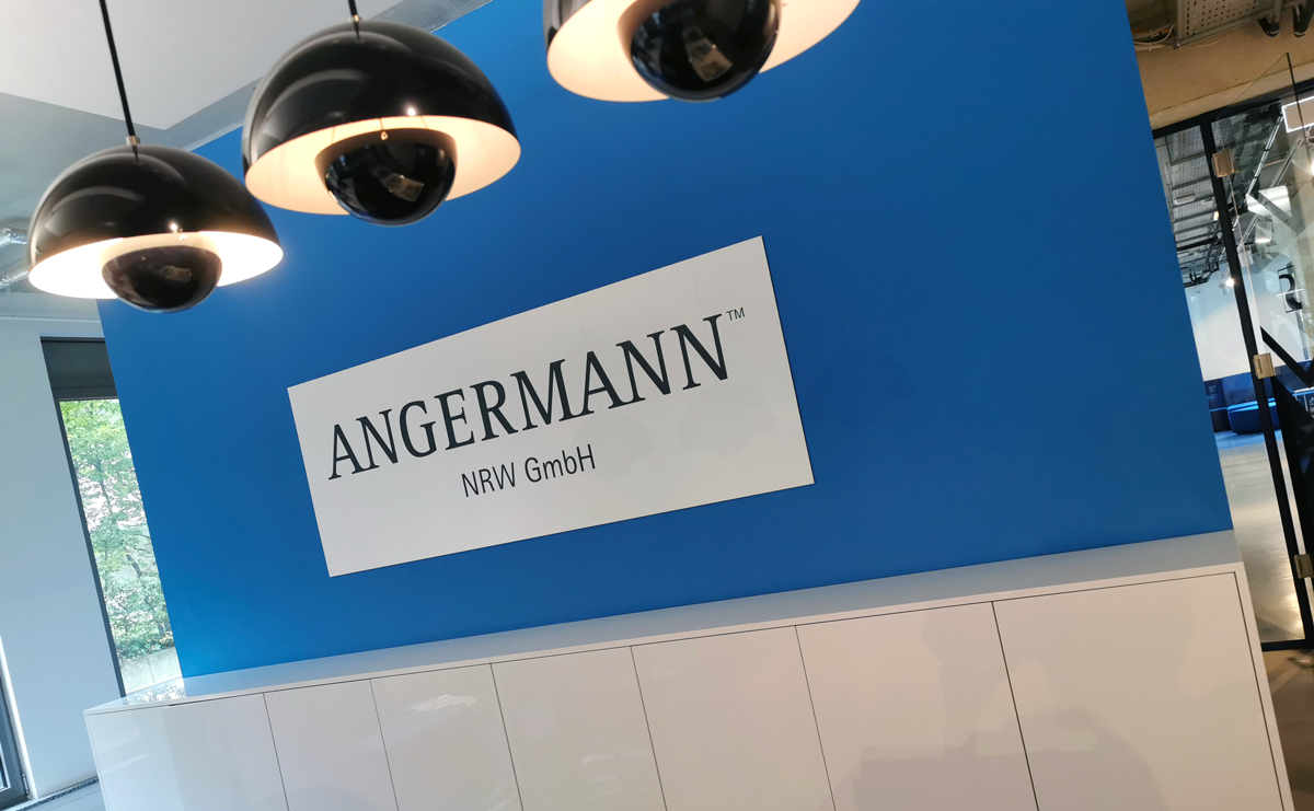 Produktion eines indoor Firmenschildes aus Aluverbundmaterial im UV Direktdruck in Firmenfarben für die Angermann NRW GmbH (vormals Rheinreal) in Köln-Müngersdorf.